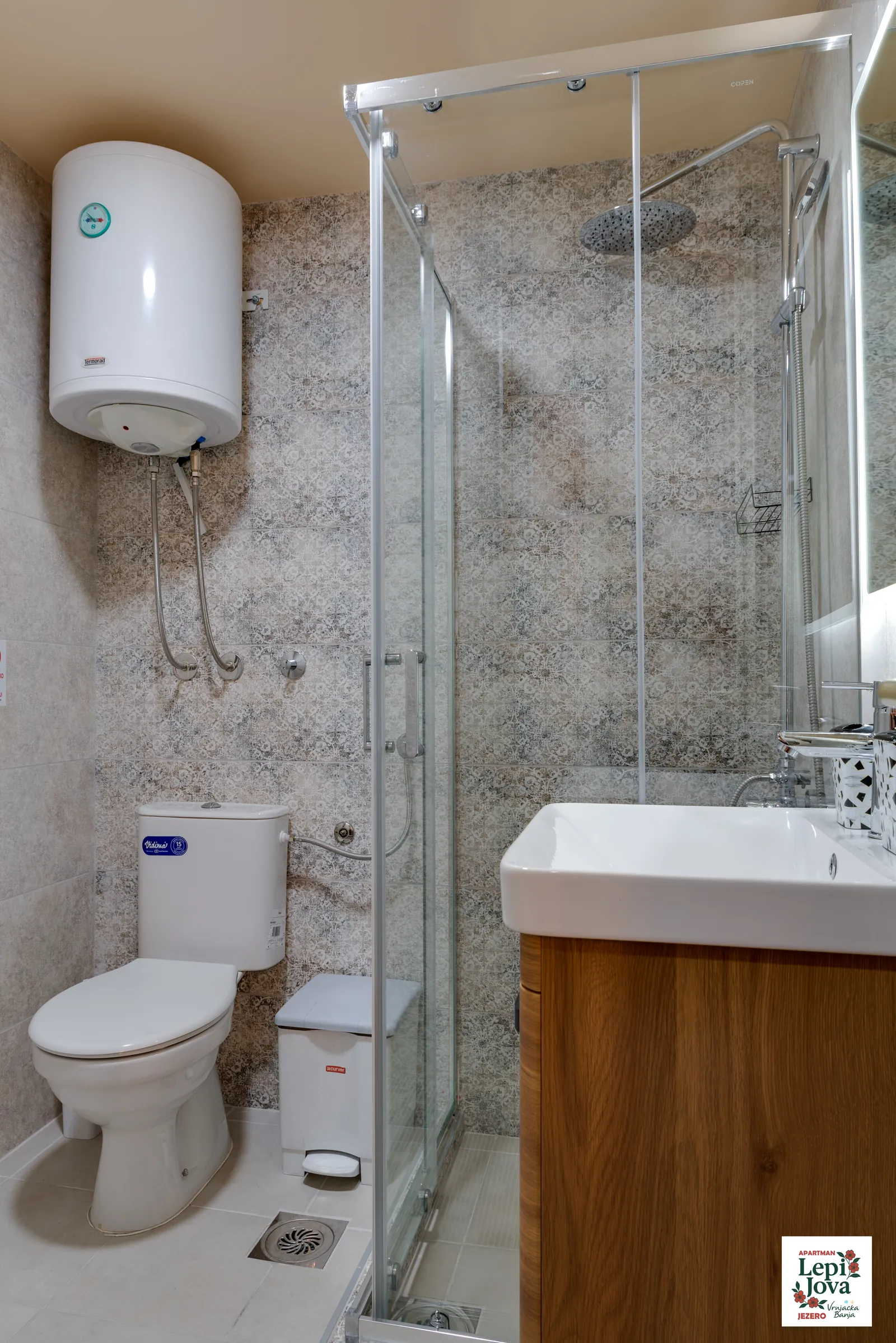 Kupatilo sa tuš kabinom i bojlerom u apartmanu Jezero